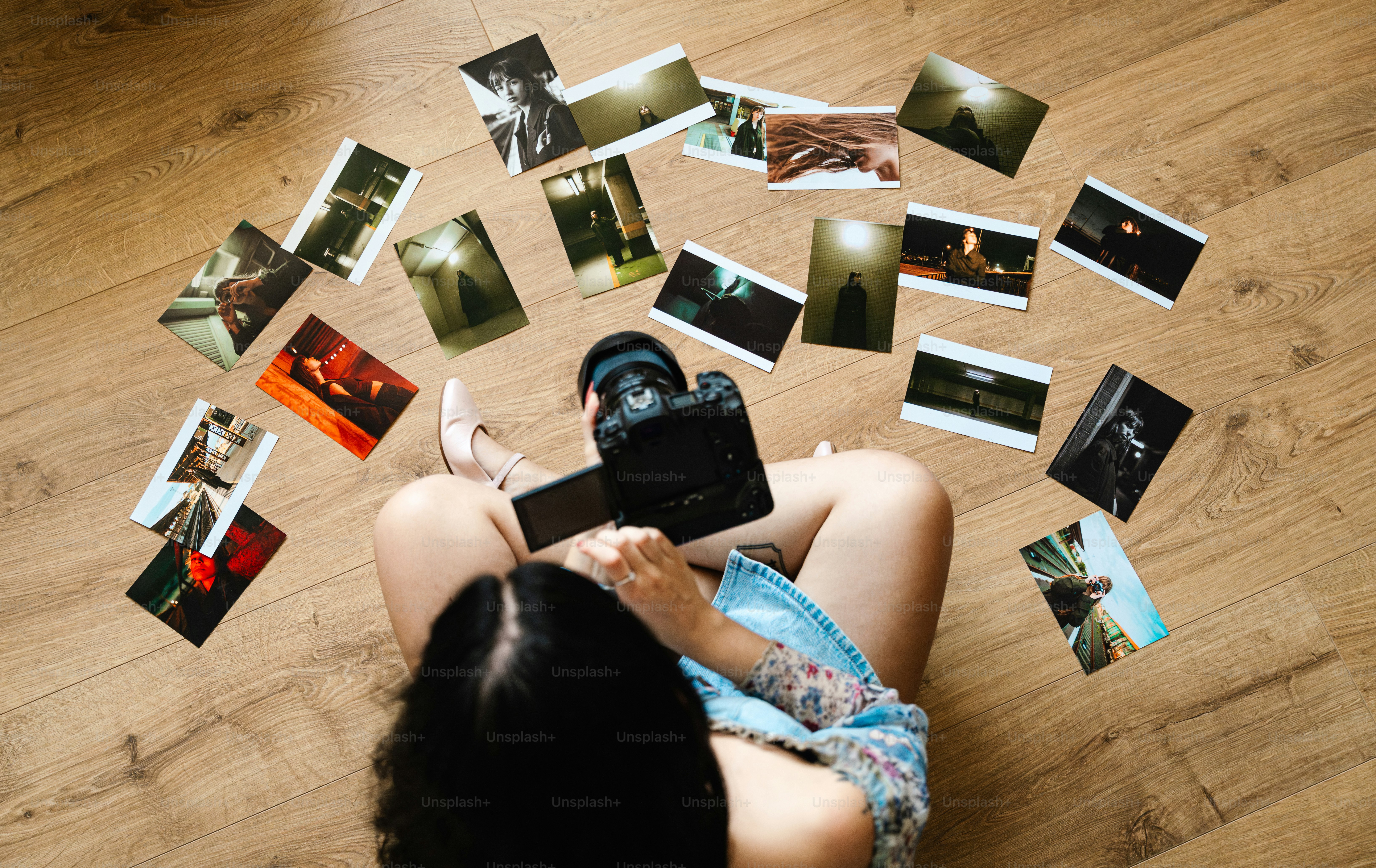 Woman surrounded by scattered photographs with camera
